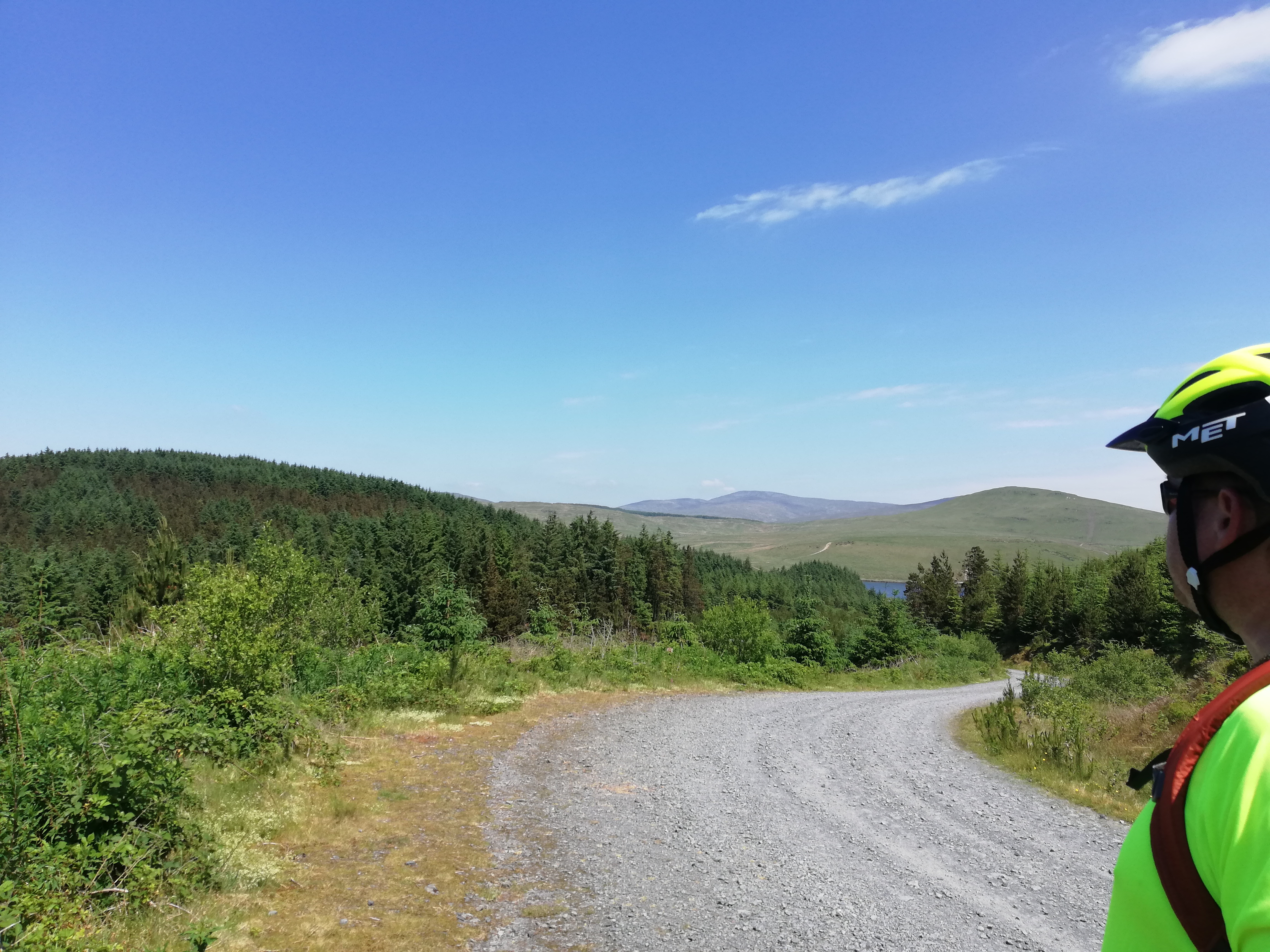 Team of 4 people linked arms on top of a valley