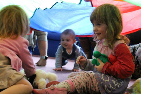 Toddlers playing under a tent in Borth Family Centre