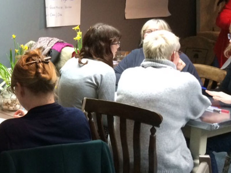 Business women sat around tables discussing business