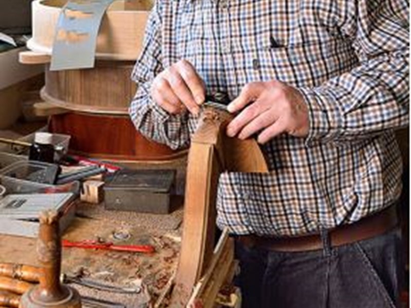 Man making a wooden harp